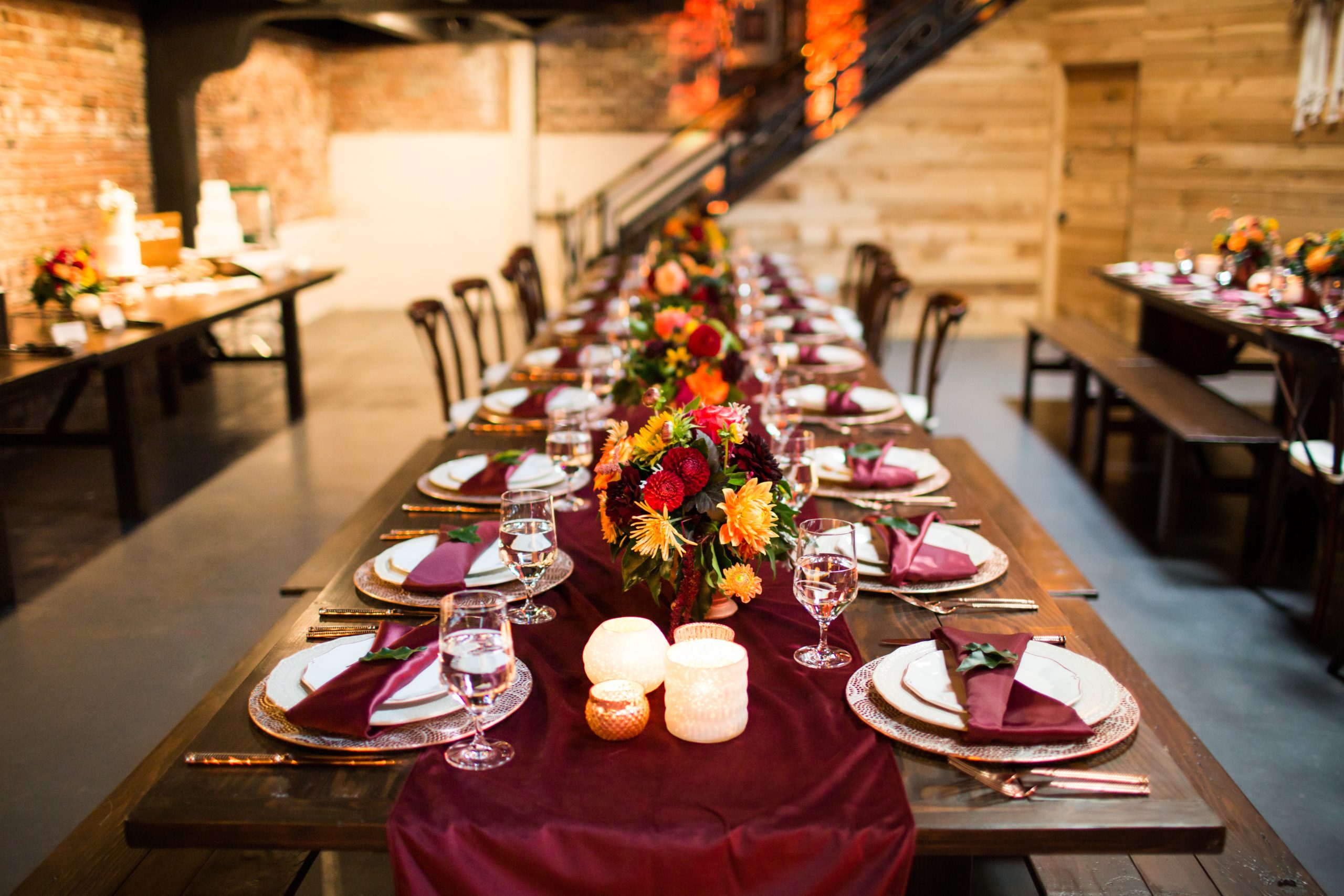 Long table with luxury plates and decorated with colorful flowers and candles